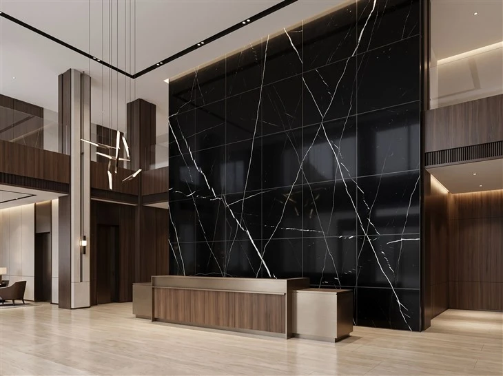 Large-format Nero Marquina marble wall tiles with visible joints behind the reception desk in a luxury hotel lobby